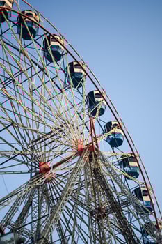 Closeup of multi-coloured Giant Wheel during Dussehra Mela in Delhi, India. Bottom view of Giant Wheel swing. Ferris wheel with colourful cabins during evening time. photo