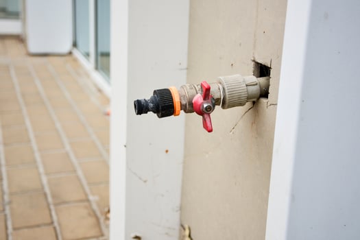 Building fire hydrants on the wall of a building. A water tap sticks out of the wall in the street. photo