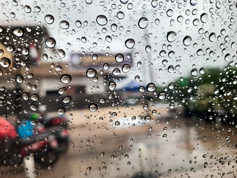 Water Droplets on Glass Window with Blurred Cityscape photo