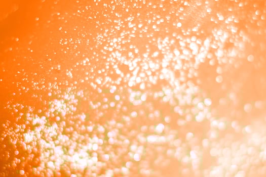 A close up of bubbles in an orange drink photo