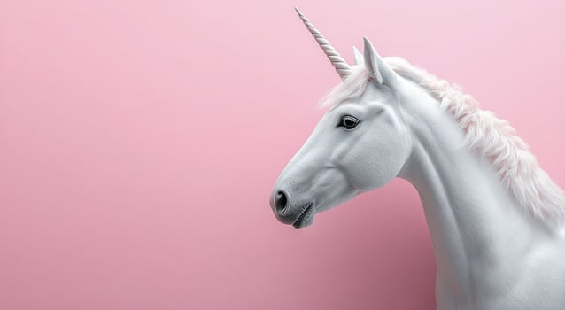 A white unicorn is standing against a pink background photo