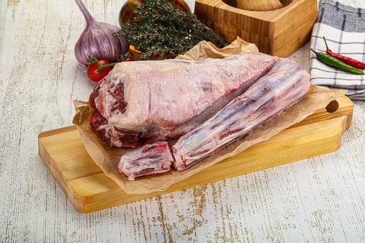 A large raw meat on a cutting board with other ingredients photo