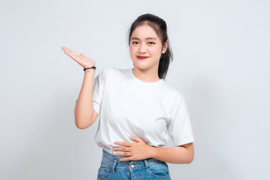 An Asian woman smiles and waves with both hands against a white background. photo