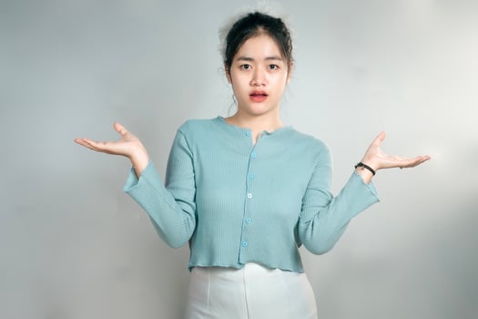 Portrait of a confused young girl shrugging her shoulders photo