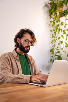 Cheerful male working with his laptop at home. photo