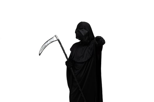 Grim reaper in Halloween costume holding scythe and pointing at the camera white background photo