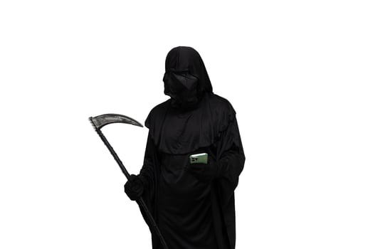 Grim reaper in Halloween costume holding scythe and texting on smartphone white background photo