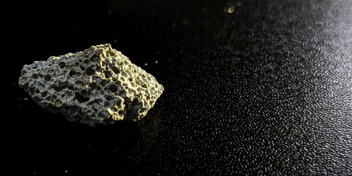 a rock sitting on a black surface photo