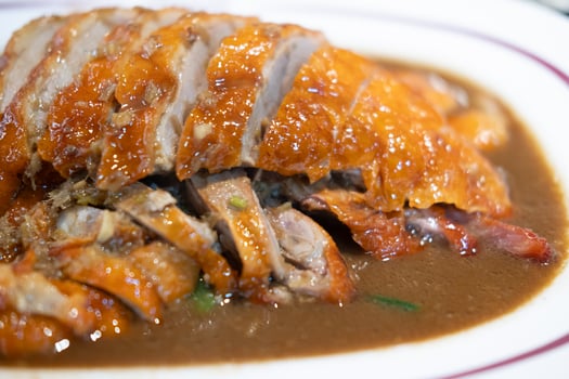 A plate of sliced roasted duck with crispy skin and juicy meat. photo