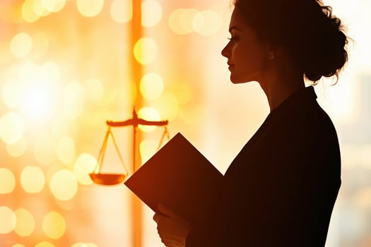 Judge holding a law book standing confidently in front of the scales of justice, illuminated by a golden glow symbolizing authority and inspiration photo