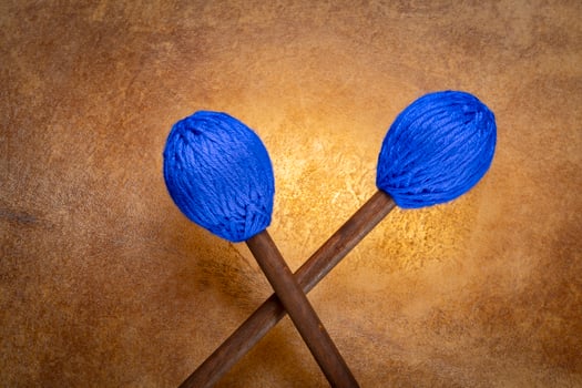 marimba mallets against backlit drum goat skin photo
