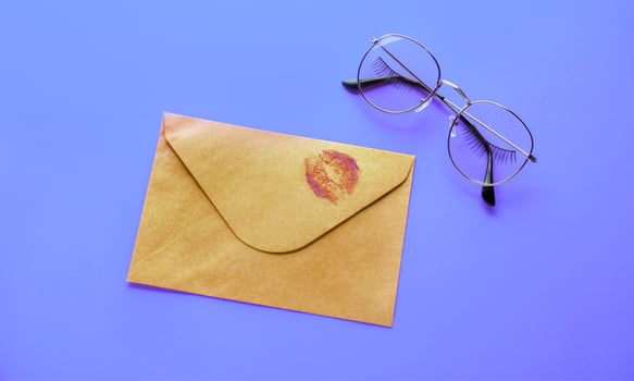 An envelope with a kiss on it and glasses on a purple background photo