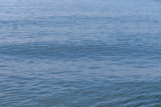 Serene blue waves dance under the sun on a tranquil coastal day photo