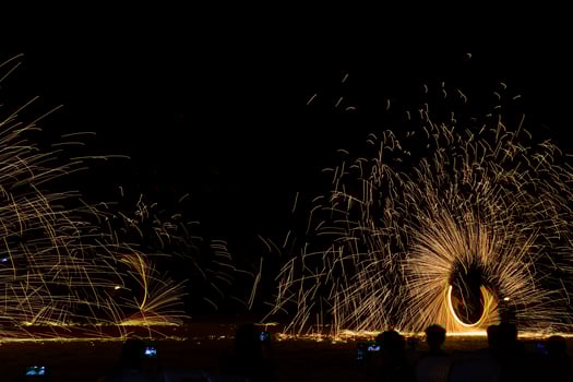 Swing fire dancing show, long exposure on the floor at the night time photo