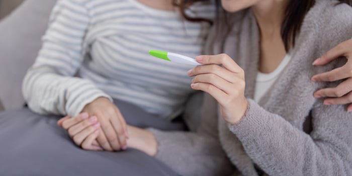 Lesbian couple celebrates ivf journey to pregnancy at home emotional moment cozy environment intimate viewpoint photo