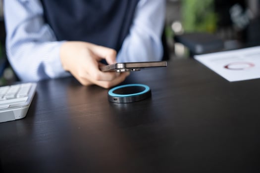 Woman charging smartphone by using magnetic wireless charger photo