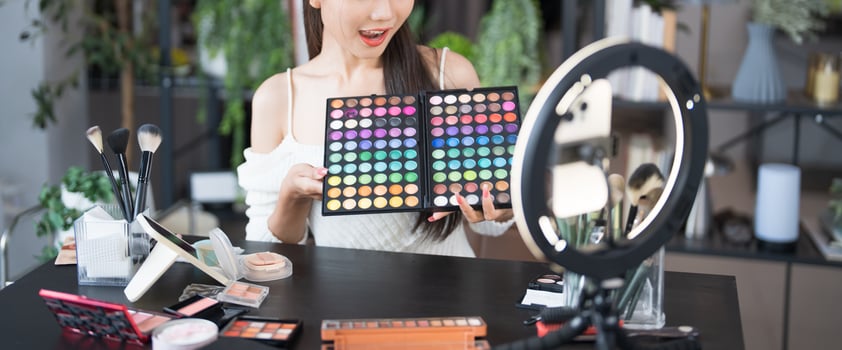 a beauty blogger woman holding up a makeup palette photo