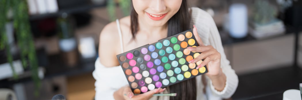 a beauty blogger woman holding a palette of makeup photo