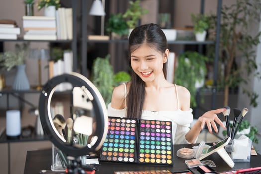 a beauty blogger woman is smiling while holding a makeup palette photo