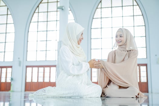 Portrait hands of two muslim women greet each other apologizing during the ramadan Eid holiday, photo