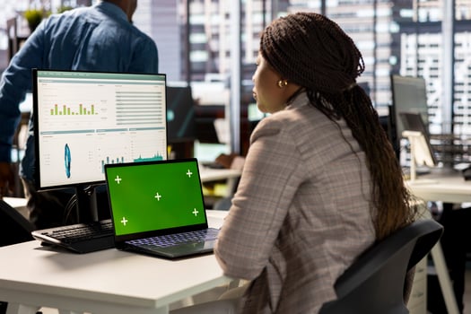 Woman at her desk working on data analysis next to mockup display, engaged in business tasks and budget management to drive effective corporate strategy. Analyst reads reports numbers. photo