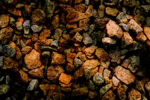 Dark orange red pebbles light stones, gravel, shadows photo