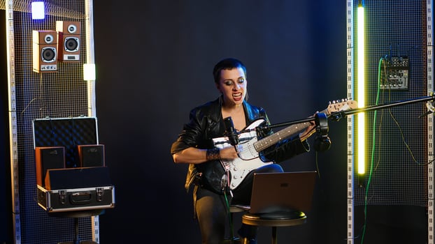 Annoyed female performer getting her vocals wrong during pre show rehearsal, doing musical warm up at practice session in the studio. Grunge rock star does performance prep. Camera B. photo