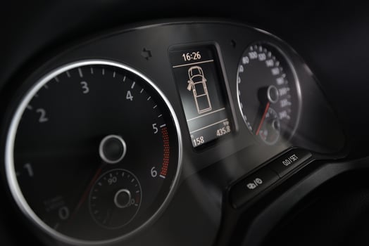 Close up of a car's dashboard showing the speedometer tachometer and digital display photo
