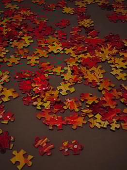 Orange Puzzle pieces scattered on brown surface, creating intriguing pattern photo
