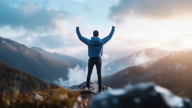 Person on Mountain Peak Celebrating Victory at Sunset Viewpoint photo