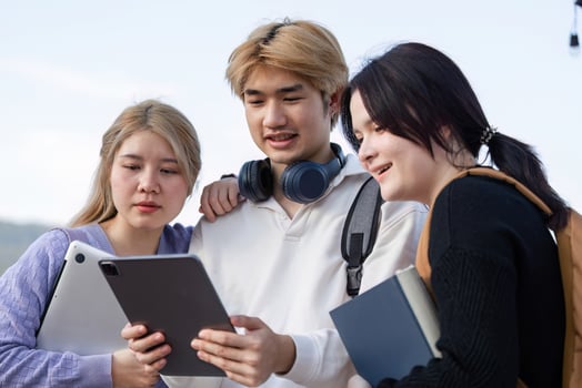 Diverse Group of Students Engaged in Online Learning Outdoors with Laptops and Tablets photo