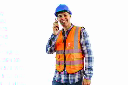 Engineer in blue helmet and orange safety vest communicating through walkie talkie white background photo