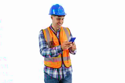 Engineer sending emails with smartphone wearing orange vest and safety helmet white background photo