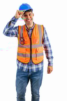 vertical Construction worker greeting the camera while touching his helmet wearing orange vest photo