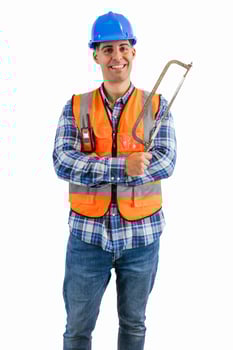 vertical Enthusiastic construction worker holding a saw wearing orange vest and safety helmet photo