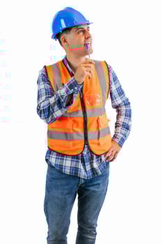 vertical Pensive construction worker biting his pen while reflecting wearing orange vest and helmet photo
