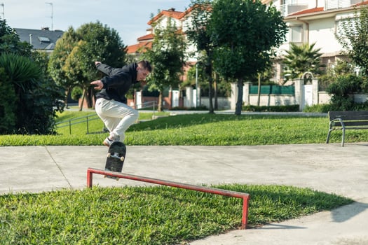 copyspace Skilled skater jumping over a red rail with their skateboard at the skate park photo