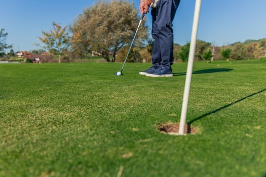 copyspace unrecognized senior golfer focused and ready to putt the ball toward the hole on the green photo