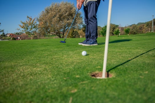 copyspace golf ball rolling toward the hole on the green after being hit by a unrecognized golfer photo