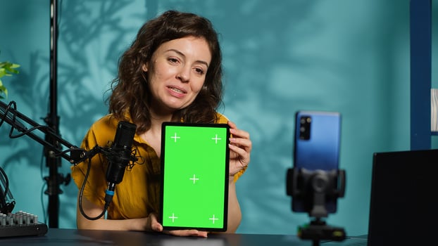 Happy technology expert at home holding newly launched green screen tablet in hand, presenting camera and screen specs. Jolly media star doing chroma key digital device review for viewers, camera A photo