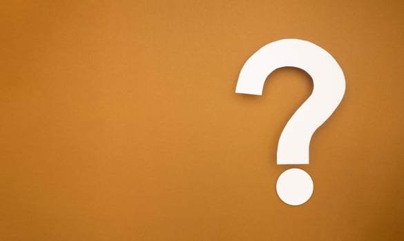 A question mark symbol is on a brown background photo