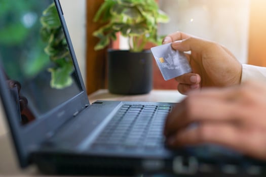 a man using a laptop to buy a credit card photo