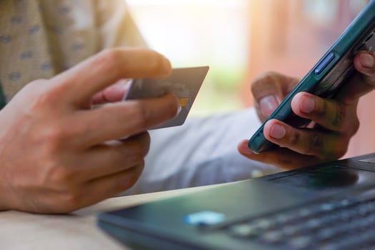 a man holding a credit card and using a laptop photo