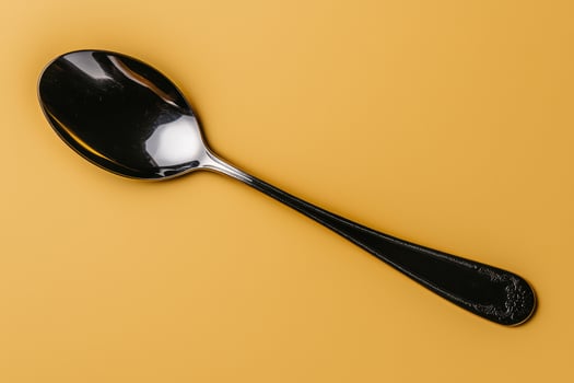 Elegant silver spoon on yellow background photo