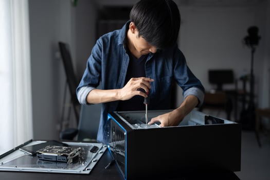 IT Engineer man is fixing a computer in a room photo