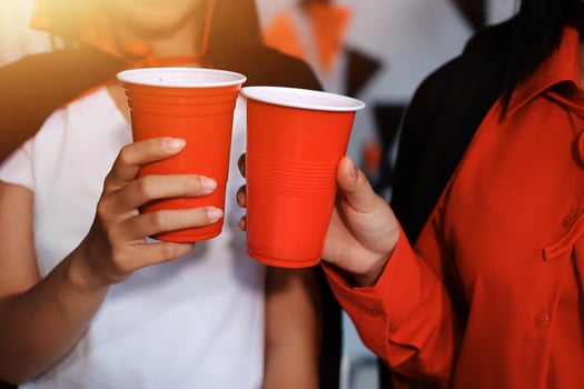 Two people holding red cups with halloween decorations photo