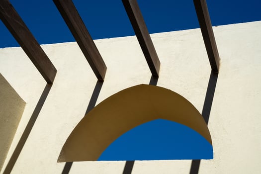 Arabic arched window on yellow wall with crossbars instead of roof photo