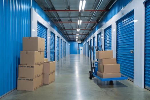 Spacious storage facility with blue walls, boxes, and polished concrete floor photo