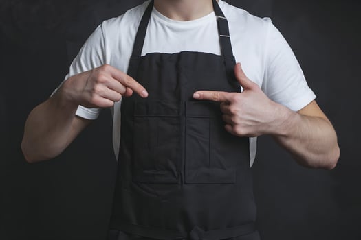 White T shirt, black apron, practical design emphasized against dark simple background photo