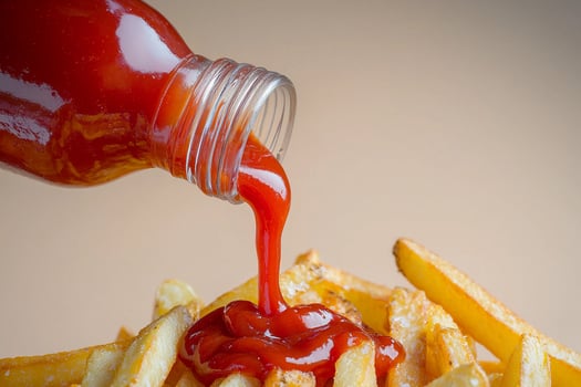 Ketchup being poured over french fries photo